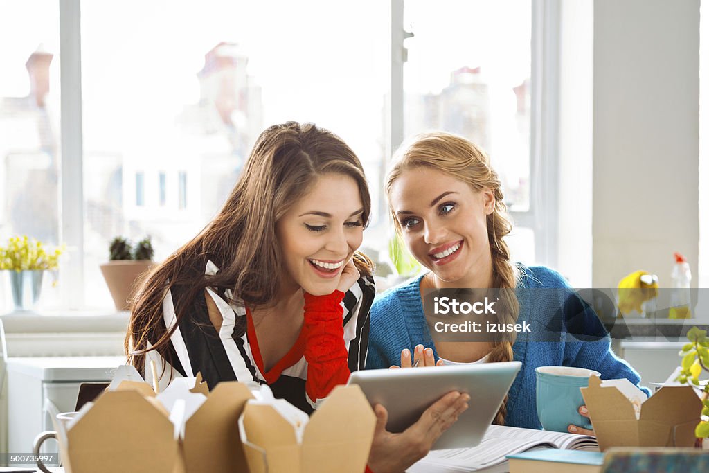 Female students learning at home Two friends sitting at the kitchen table at home and learning together. 20-24 Years Stock Photo