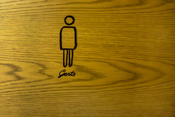 A wooden sign with a woman on it is hanging on a door. The sign is black and white and has a toilet symbol on it. The sign is placed on the door so that people can easily see it
