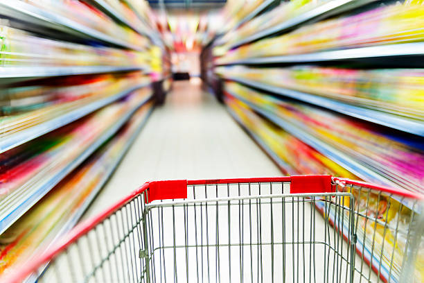 istock Supermarket interior, empty red shopping cart. 500740515
