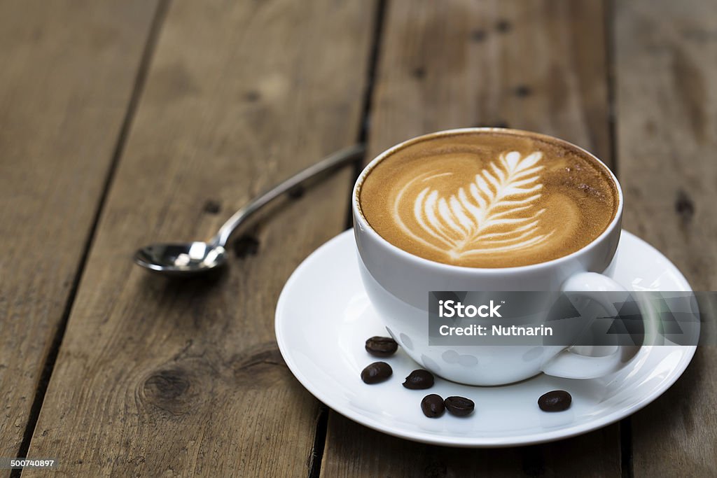 Cup of hot latte art coffee on wooden table Cappuccino Stock Photo