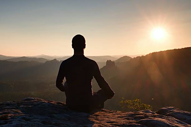 istock Hiker in squatting position on a rock, enjoy dybreak  scenery 500745944