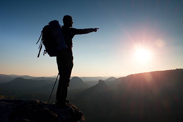 istock Sharp silhouette of man with sun in frame. Tourist guide 500745990