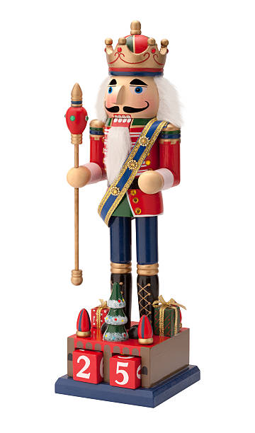 Antique Christmas Royal Nutcracker Antique Christmas Royal Nutcracker holding a scepter. He wears a crown and sash with his uniform and is isolated on a white background. nutcracker photos stock pictures, royalty-free photos & images