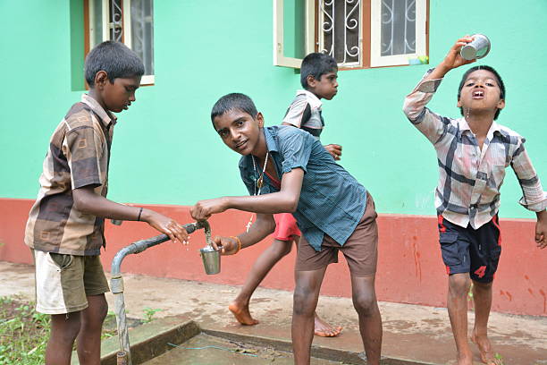 Learning kids Mumbai, India - October 27, 2015 - Children from childrens home drinking water and washing dishes from new well powered by charity from europe unicef stock pictures, royalty-free photos & images