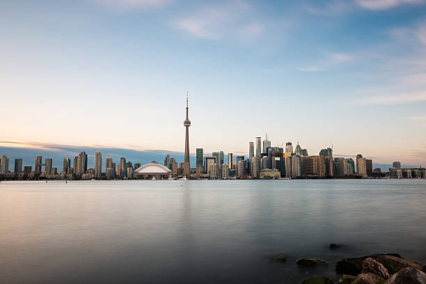 Toronto skyline at dusk Toronto skyline with Lake Ontario in the foreground, as seen from Center Island. Long exposure. toronto photos stock pictures, royalty-free photos & images