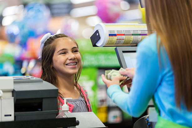 rapariga a pagar compras em loja de mercearia com dinheiro - cash register register wealth checkout counter imagens e fotografias de stock