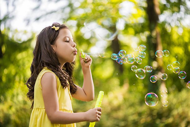 istock Little girl blowing soap bubble 500750281