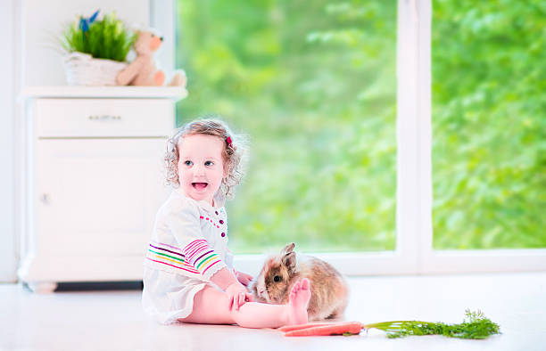 istock Adorable girl playing with a bunny 500751835