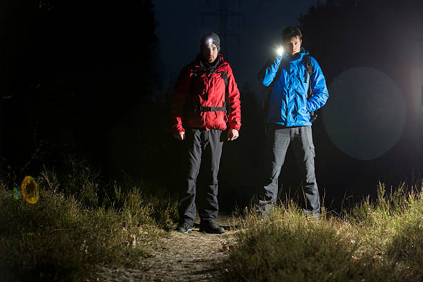 istock Hikers with flashlights in field at night 500753627