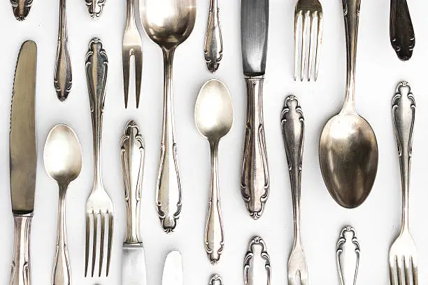 Photo of beautiful sterling cutlery set on white background