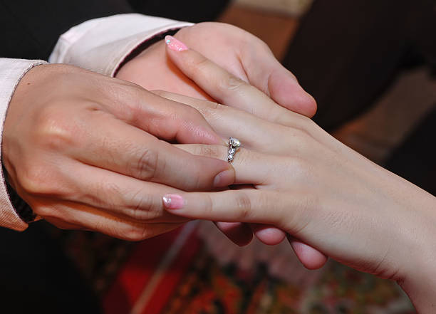 istock engagement ring, bride and groom hands close up ring 500758240