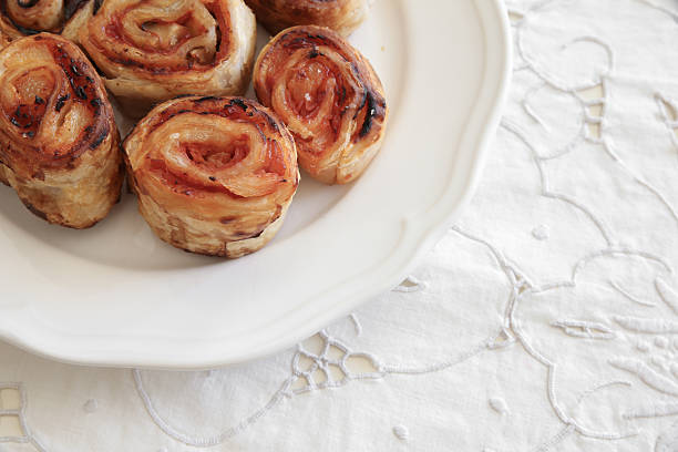Homemade Hawaiian pizza rolls on white serving plate, soft selective focus, copy space background