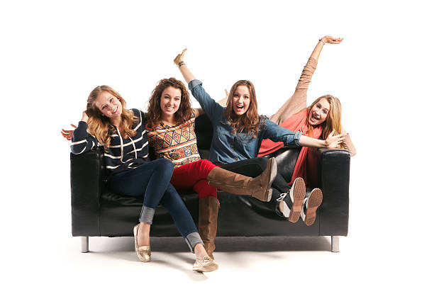 istock Playful Young Women Models with Black Sofa on White Background 500764155