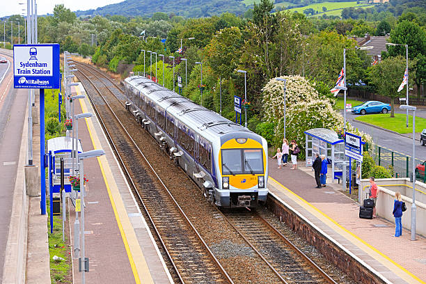 Belfast, United Kingdom - August 6, 2011: Passengers of all ages and gender wait at Sydenham Station on the Bangor line for a Northern Ireland Railways commuter train to Belfast Central.  
