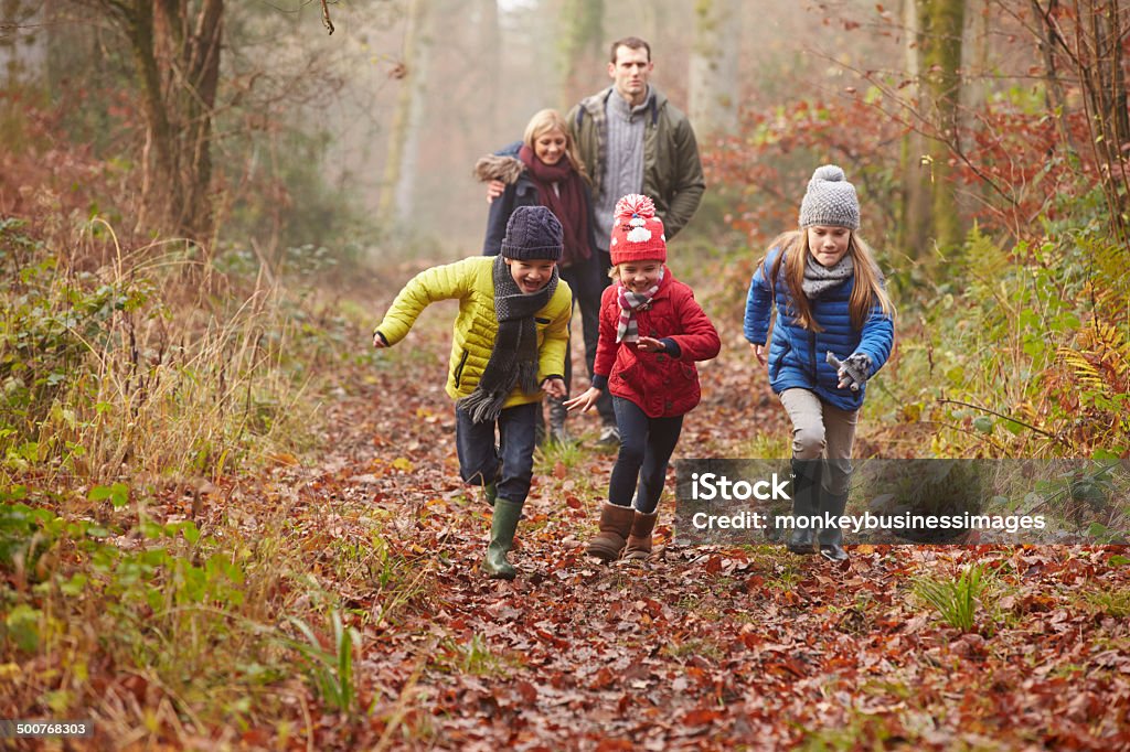 Familia caminando a través de un bosque de invierno - Foto de stock de Familia libre de derechos