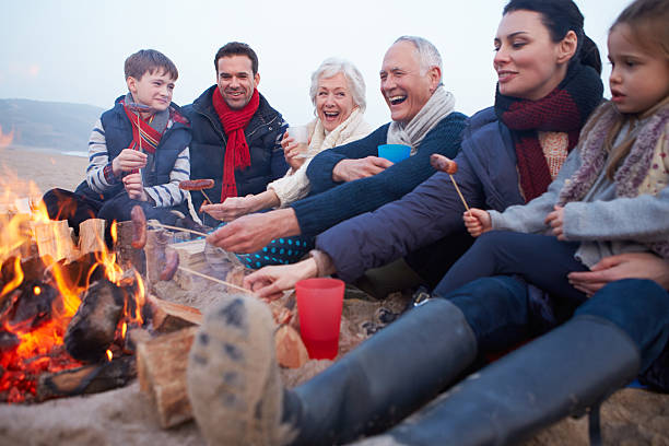 Multi Generation Family Having Barbeque On Winter Beach Multi Generation Family Having Barbeque On Winter Beach Relaxing family bbq beach stock pictures, royalty-free photos & images