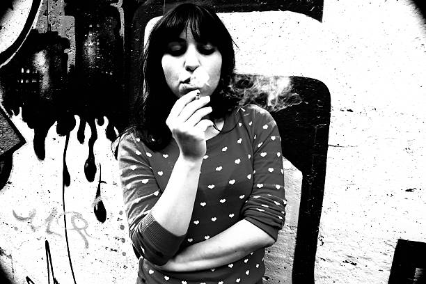 istock young cute woman smoking a cigarette on a graffiti background 500771387