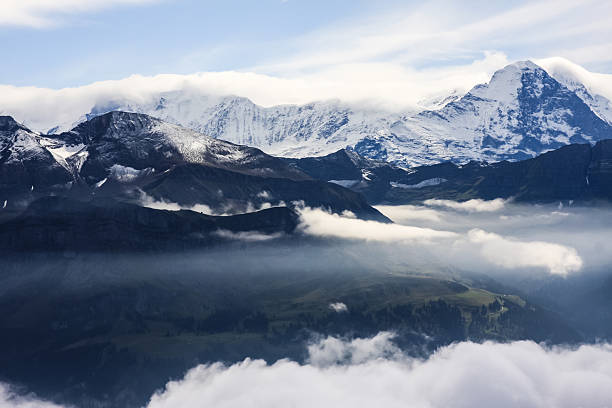 Sarnersee (lake) beneath fog lingering around snowy peaks of Tannhorn Brienzer Rothorn, Arnihaaggen and Schwalmere massif.
