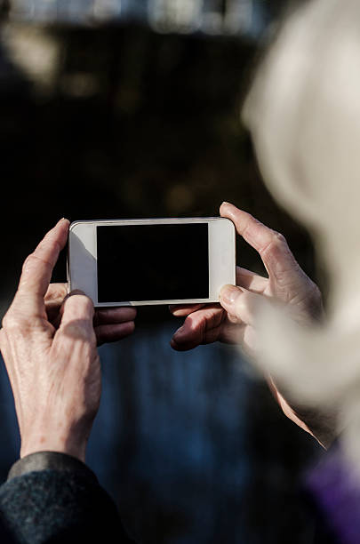 istock Old woman with grey hair communicating on a smartphone 500776720