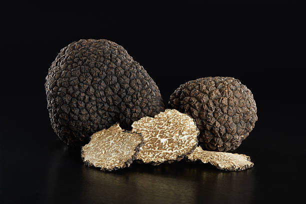 Black truffles and slices on black Black truffles and slices on black, clipping path included black truffle stock pictures, royalty-free photos & images
