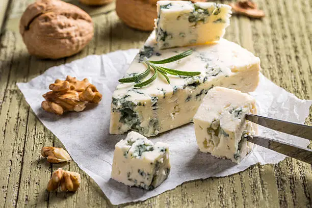 Cheese with mold on wooden background