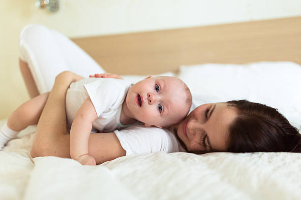 istock baby kid with mom playing on a bed under  blanket, 500783708