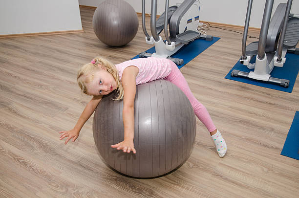 istock girl exercising with fit ball 500786574