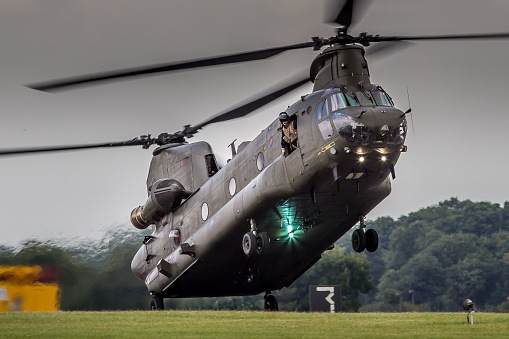 Waddington, UK - July 6, 2014: a Chinook military transport helicopter operated by Britain's Royal Air Force demonstrates a rolling landing technique at an air show in Lincolnshire, England. 