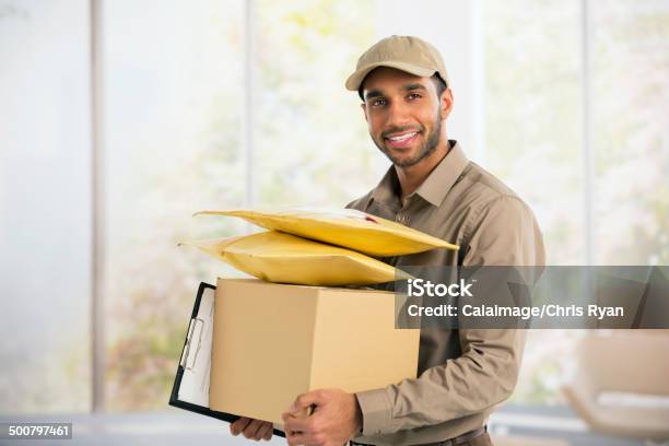 Portrait Of Confident Deliveryman Stock Photo - Download Image Now - Delivery Person, Cardboard Box, Happiness