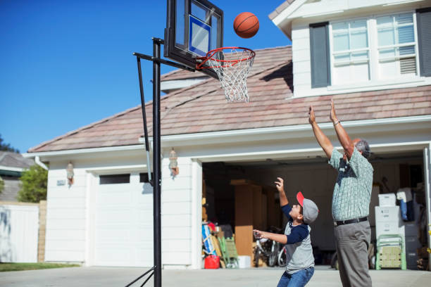 großvater und enkel spielen basketball in der einfahrt - basketball basketball hoop california southern california stock-fotos und bilder