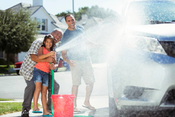 carro de lavagem de família de várias gerações na garagem - washing water car cleaning - fotografias e filmes do acervo