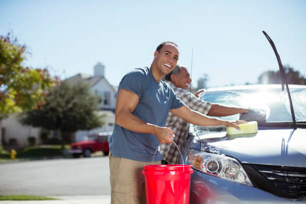 padre e figlio che lavano l'auto nel vialetto - wash stand foto e immagini stock