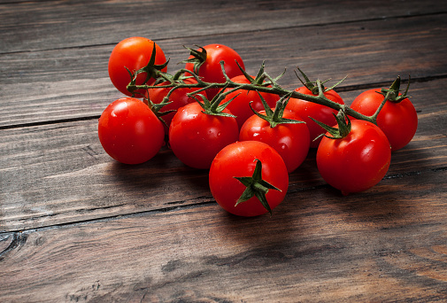 Fresh cherry tomatoes on wood background. Organic food