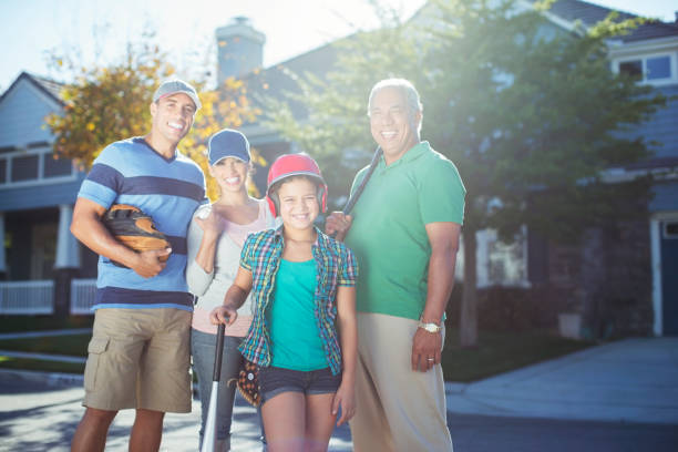 Portrait of smiling multi-generation family with baseball bat in street  men baseball baseball cap baseball bat stock pictures, royalty-free photos & images