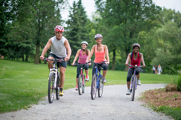 adulti in bicicletta attraverso il parco - trail bike foto e immagini stock