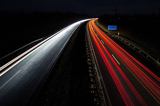 istock Car light trails with blue road sign, long exposure 500801034