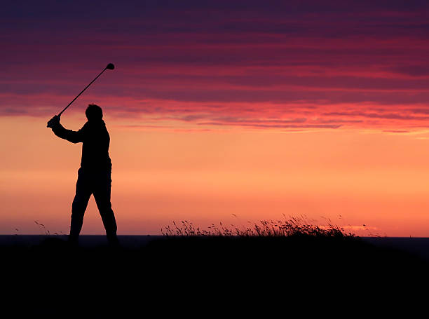 ゴルファーの最終のお車は、一日の終わりには、夕日をご覧ください。 - 18th hole ストックフォトと画像