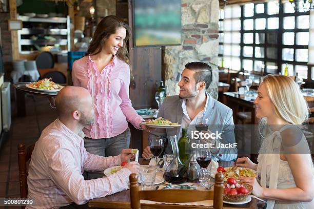 Waiter With Restaurant Guests At Table Stock Photo - Download Image Now - 2015, Adult, Alcohol Abuse
