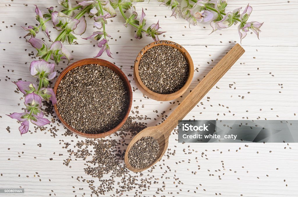 Chia seed healthy super food with flower over white Chia seed healthy super food with flower over white wood background. Salvia hispanica. Chia seed Stock Photo
