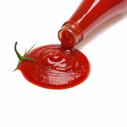 Ketchup is poured from a bottle in the shape of a tomato.