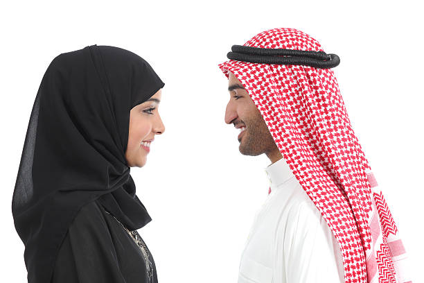 Side view of an arab saudi couple looking each other Side view of an arab saudi couple looking each other isolated on a white background couple isolated wife husband stock pictures, royalty-free photos & images