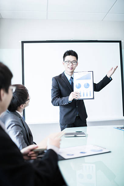 istock businessman giving a presentation to his colleagues 500803109