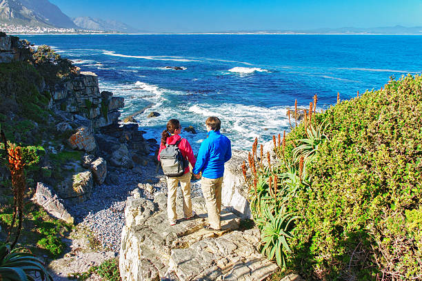 istock Happy couple hiking and looking at beautiful ocean view 500803403