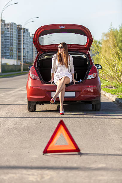 istock helpless woman sitting near broken red car 500804171