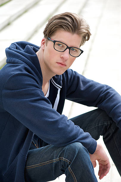 istock Cool young guy sitting outdoors 500804357