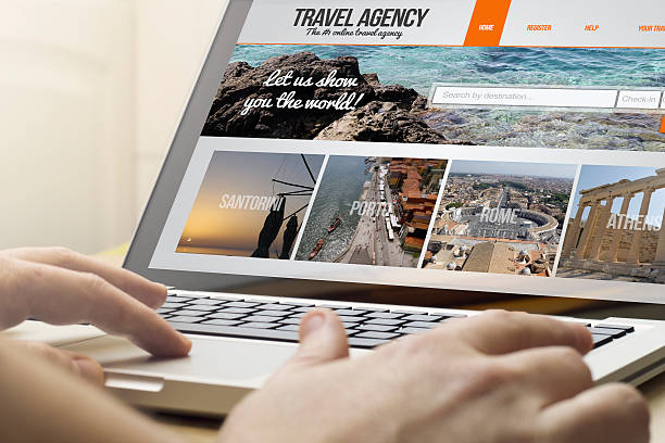 home computing travel agency online travel concept: man using a laptop with travel agency on the screen. Screen graphics are made up. travel agency stock pictures, royalty-free photos & images