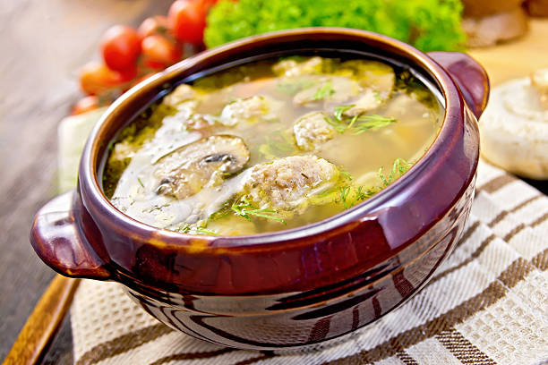istock Soup with meatballs and spoon in pottery on dark board 500805388