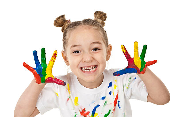 istock Little girl making a face with hands covered with paint 500805438