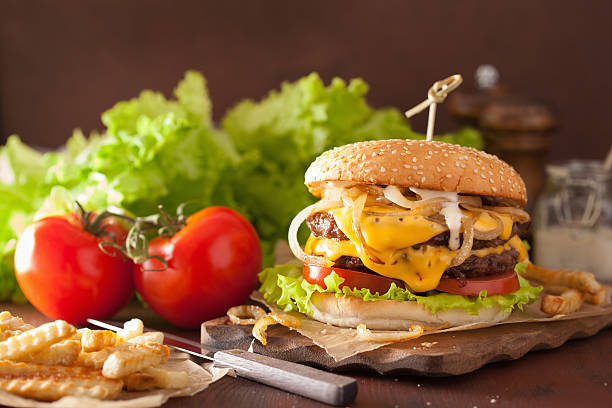 double cheeseburger accompagné de tomates et d'oignons - symmetry burger hamburger cheese photos et images de collection