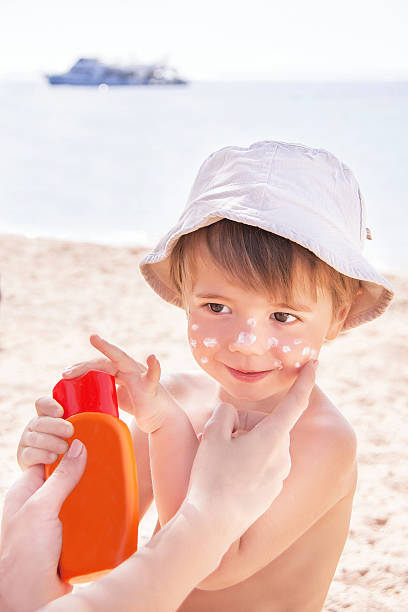 istock Mother putting sunscreen on young son at the beach 500805963
